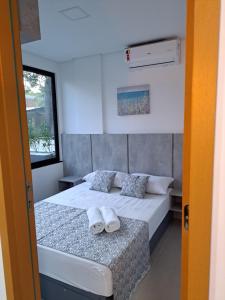 伊波茹卡Apartamento com piscina no Condominio Maraca2的一间卧室配有带毛巾的床