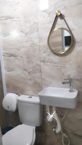 瓜鲁柳斯维多利亚旅馆的一间带卫生间、水槽和镜子的浴室