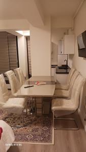 奥托佩尼Trio Maria的一间带桌子和白色椅子的用餐室