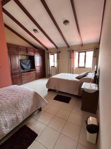 科恰班巴Hermosa y cómoda casa en Cochabamba的一间带两张床和电视的卧室