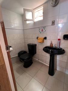 科恰班巴Hermosa y cómoda casa en Cochabamba的浴室设有黑色的卫生间和水槽。