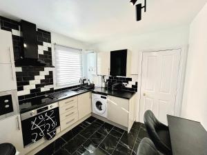 伦敦Fabulous One Bedroom House in Penge area in London的厨房的墙壁上铺有黑白瓷砖。