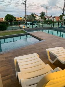 德奥多鲁元帅镇Apartamento a Beira-Mar - Praia do Francês的游泳池旁设有床和长凳