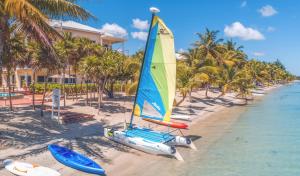 珀拉什奇亚Laru Beya All Inclusive Resort的棕榈树海滩上的帆船和皮划艇