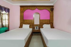 菩提伽耶OYO Hotel C K International的配有镜子的客房内的两张床