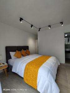 洛佩斯港Centro Vacacional "El Pro"的卧室配有一张带黄毯的大型白色床