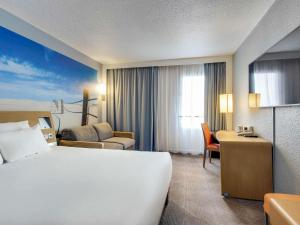 巴涅奥莱诺沃特巴黎东部酒店的酒店客房设有一张大床和一张书桌。