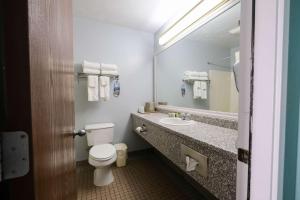 贝尔法斯特Fireside Inn, Ocean's Edge的一间带卫生间、水槽和镜子的浴室