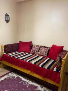 卢克索Oscar Apartment { 5 }的客厅里配有红色枕头的沙发