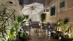 麦地那Lenda House的庭院配有桌椅和遮阳伞。