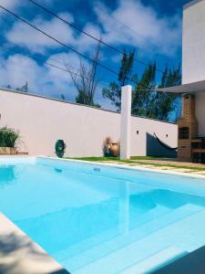 卡波布里奥Casa com piscina exclusiva的白色墙壁前的游泳池
