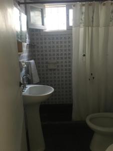 马德普拉塔Silvestre的一间带水槽和卫生间的浴室以及窗户。