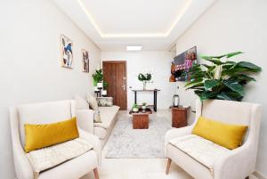 马拉喀什Appartement Cosy Marrakech Centre GUELIZ的客厅配有白色家具和黄色枕头。