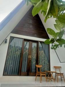 金塔马尼Mahadanu Villa & Glamping的房屋设有大窗户和两把椅子