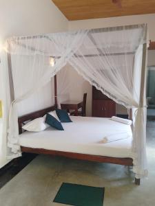 乌纳瓦图纳乌纳瓦图纳背包客旅馆 的一间卧室配有一张带天蓬的白色床