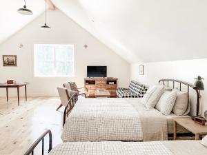 索诺拉Homestead Barn Loft的白色的客厅配有两张床和电视