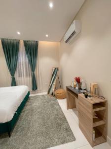 艾卜哈نزل الراشد الفاخرة luxury的一间卧室配有一张床、一张书桌和一个窗户。