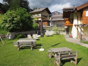 CampestrinResidence Rodolon Appartamenti的草地上带两张野餐桌和椅子的院子