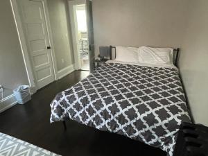 波士顿3 HOMESTAY At Boston In Dorchester or JFK-UMASS or South Boston的一间卧室配有一张带黑白色棉被的床