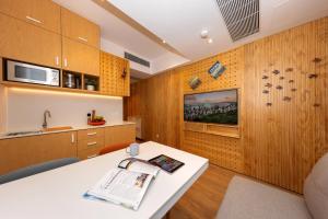 香港Shama Hub Metro South Hong Kong的厨房配有木制橱柜和白色桌子。