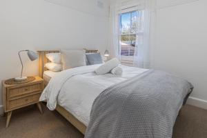 悉尼Luxe-Coastal Balmoral Beachfront Apartment的白色的卧室设有床和窗户