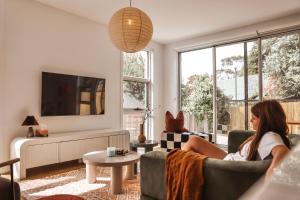 霍巴特Architect Home with View in Central Hobart的坐在客厅沙发上的女人