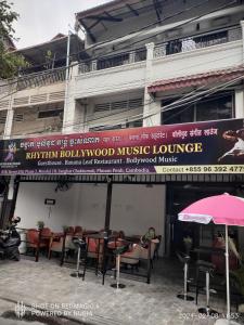 金边Rhythm Bollywood Guesthouse的建筑前音乐休息室的标志