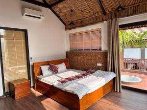 巴位Thang Mây Village Resort的一间卧室配有一张带窗户和浴缸的床。