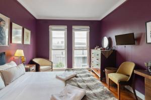 悉尼Great Gatsby Style in the Heart of Double Bay的一间卧室设有紫色的墙壁、一张床和一台电视机。