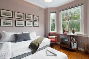悉尼Great Gatsby Style in the Heart of Double Bay的一间卧室配有一张床、一张书桌和一个窗户。