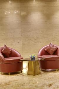 新德里Hotel International Inn by Star group - Near Delhi Airport的客房内的2把椅子和1张茶几