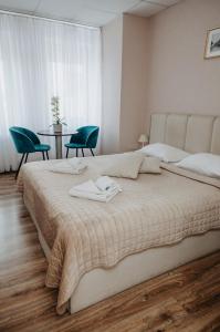 帕内韦日斯Verslo Klasė-easy to stay的一间卧室配有一张大床、两把椅子和一张桌子