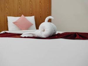 董里S2S皇后庄酒店的一只白毛巾动物坐在床上