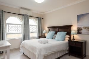 巴利托La Mustique 4的一间卧室配有一张带蓝色枕头的床和两个窗户。
