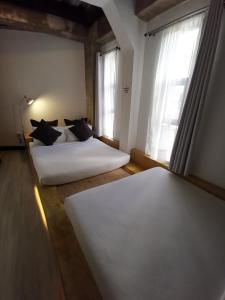 长滩岛都市精品酒店的一间卧室设有两张床和两个窗户。