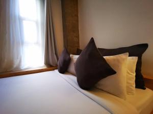 长滩岛都市精品酒店的一张带黑白枕头的床和窗户