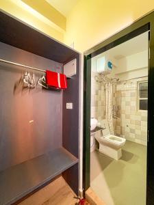 古瓦哈提Irroi Guwahati的一间带卫生间和红色钱包的浴室