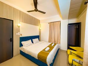 古瓦哈提Irroi Guwahati的一间卧室配有一张大床和一张黄色椅子