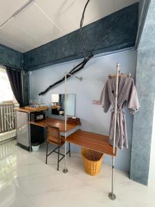 攀牙ลอดจ์พังงา บูทีค的一间房间,配有书桌和挂在墙上的外套
