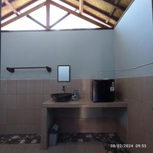 吉利阿尔坦加简易别墅的浴室设有水槽和镜子,位于柜台上
