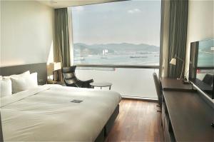 昌原市Sky View Hotel的酒店客房设有一张床和一个大窗户