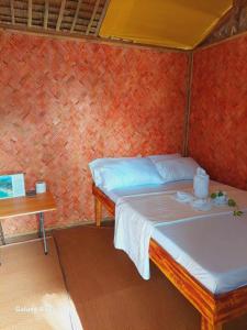 爱妮岛Kubo Inn & Beach Camp的一间小卧室,配有一张床和一张桌子