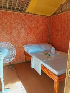 爱妮岛Kubo Inn & Beach Camp的小房间设有一张床和一把椅子