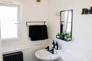 伦敦Fabulous One Bedroom House in Penge area in London的白色的浴室设有水槽和镜子