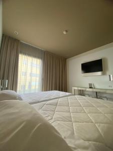 达尔米内One Hotel & Restaurant的卧室配有一张白色大床和电视。