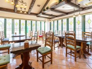雫石町shizukuishi RESORT HOTEL的餐厅设有木桌、椅子和窗户。