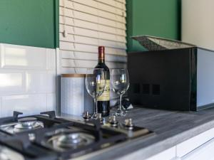 普利登堡湾Cliffside Suites的炉子上放一瓶葡萄酒和两杯酒