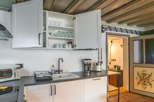 胡芬根Black Forest Moments inkl. Sauna für 8 Personen的厨房配有白色橱柜和水槽