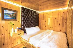 大叻Dớt's Garden Homestay的卧室配有一张床铺,位于带木墙的房间内