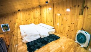 大叻Dớt's Garden Homestay的小房间,木墙里设有一张床